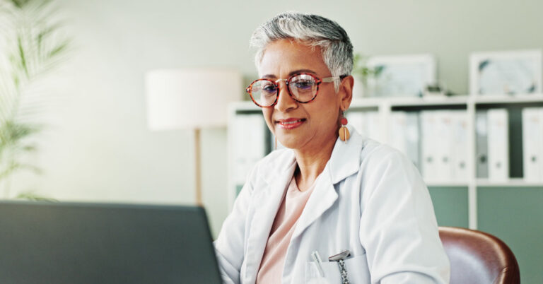 Behavioral health provider working with EHR on computer.