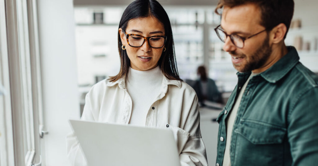 Two behavioral health workers looking at EHR system on a laptop computer