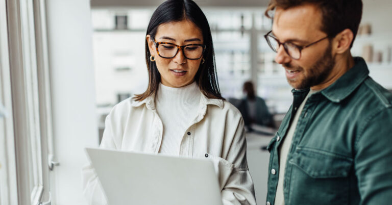 Two behavioral health workers looking at EHR system on a laptop computer