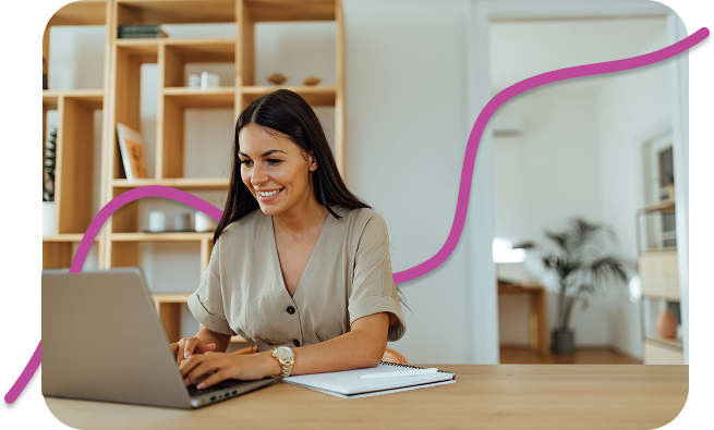 Smiling woman typing on a laptop at a wooden desk, with a pink wave line design in the background, in a bright, modern home office setting.